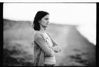 Black and white photo of a thoughtful person looking out to the sea, symbolizing depth and clarity.