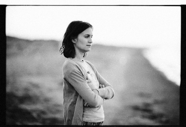 Black and white photo of a thoughtful person looking out to the sea, symbolizing depth and clarity.
