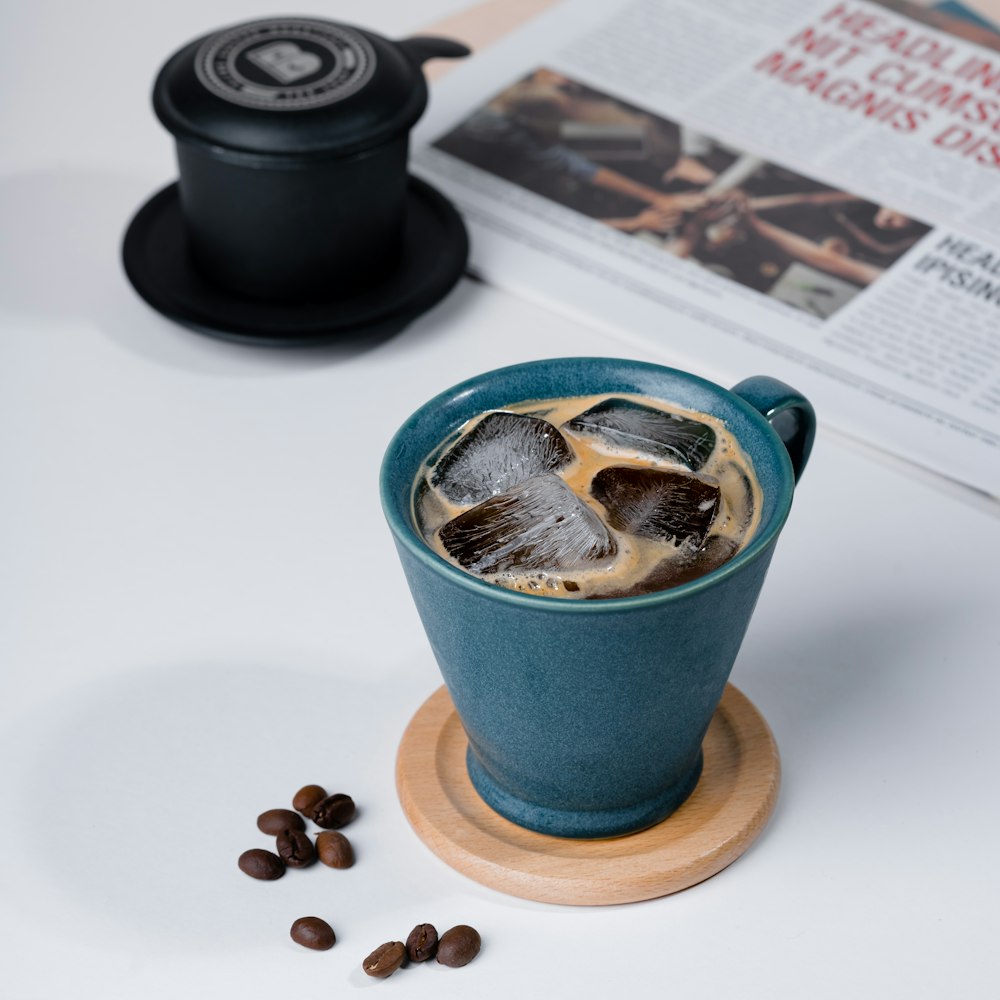 a cup of coffee with ice and coffee beans