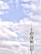 A telecommunications tower stands against a backdrop of a partly cloudy sky. The structure is equipped with various antennas and equipment, suggesting its use for communication purposes.