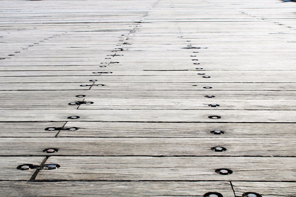 a close up of a wooden floor with holes in it