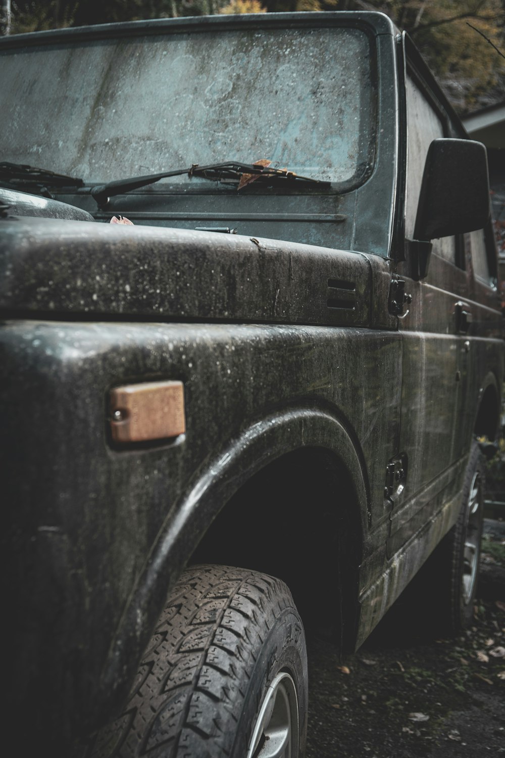a black truck parked in a wooded area