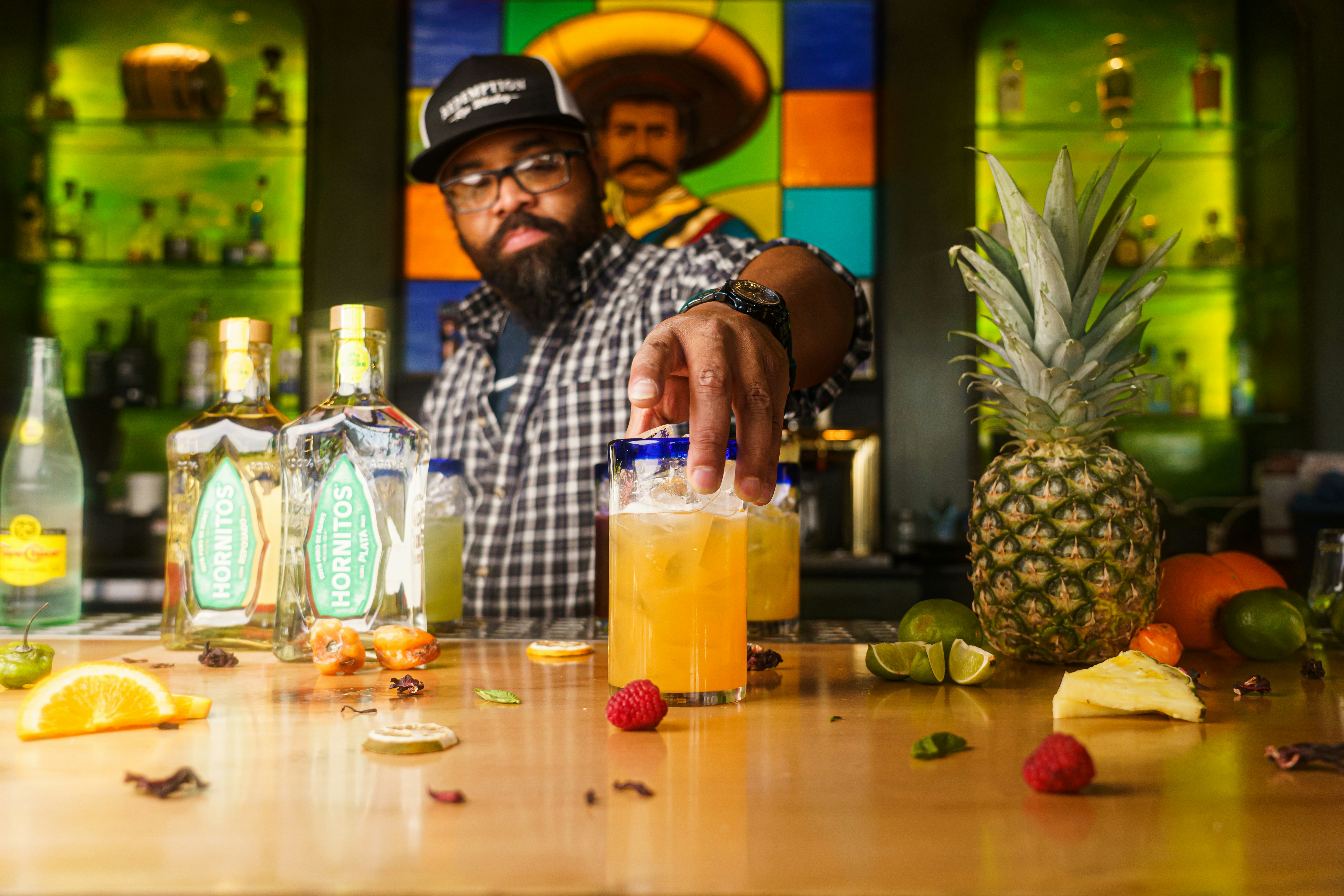 Bartender making a drink at a colourful bar