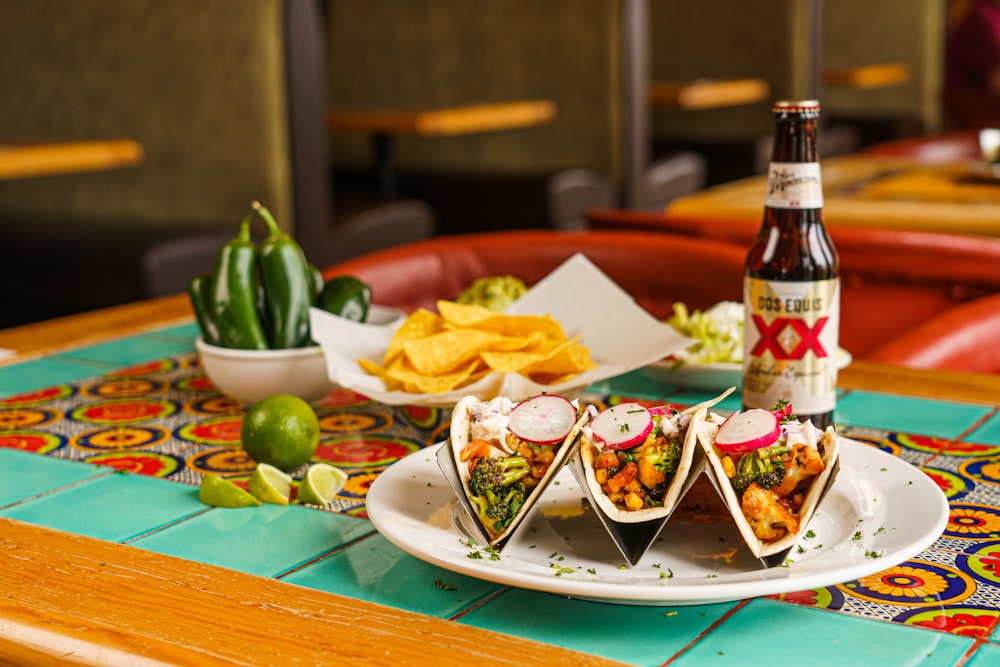 a plate of food and a bottle of beer on a table