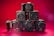A collection of professional cameras is arranged against a vibrant red background. The setup includes multiple RED brand cameras and one Canon EOS R5 camera positioned at the top. The cameras are stacked in a pyramid-like fashion, emphasizing their robust and advanced design.