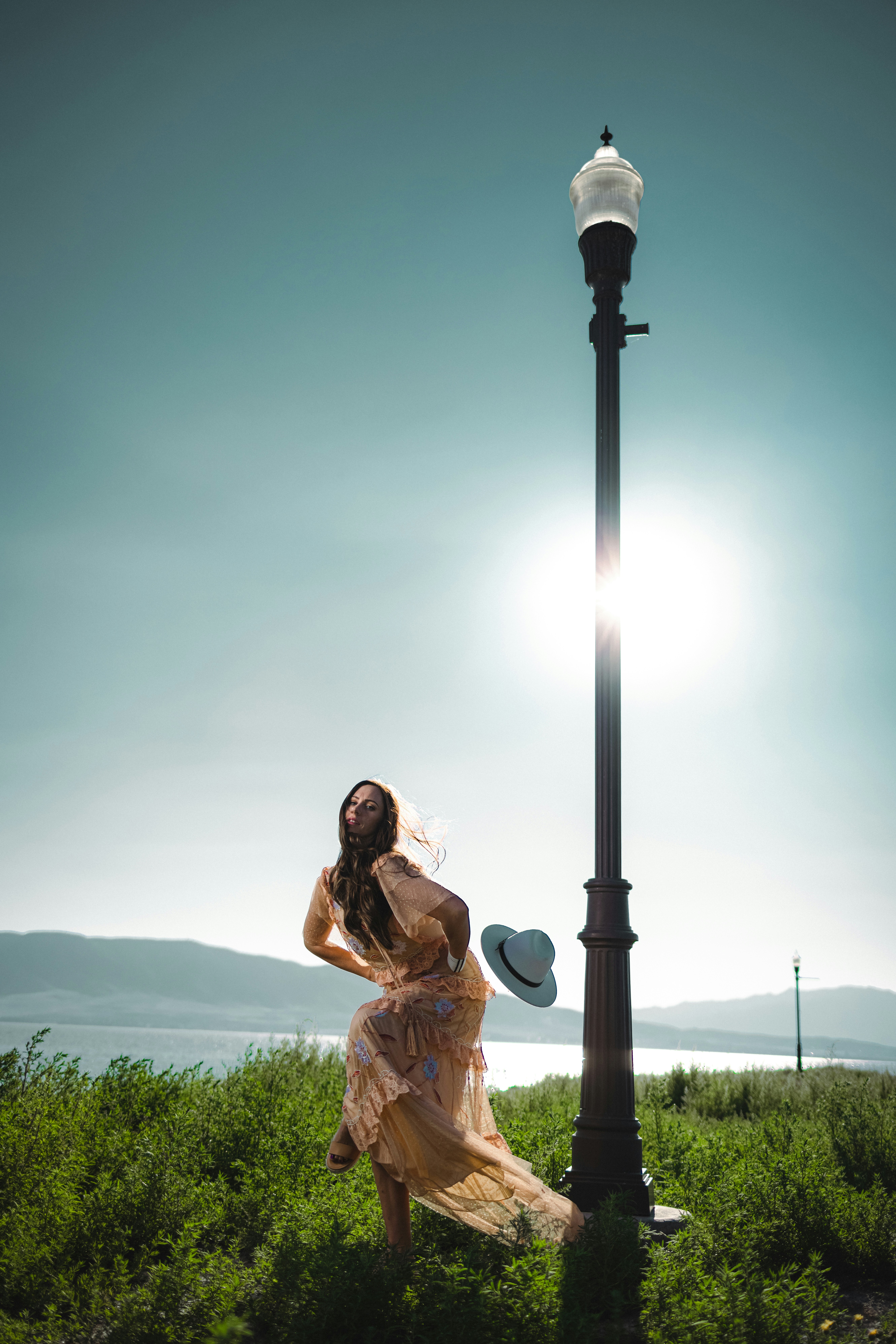 Eine Frau steht neben einem Laternenpfahl auf einem Feld