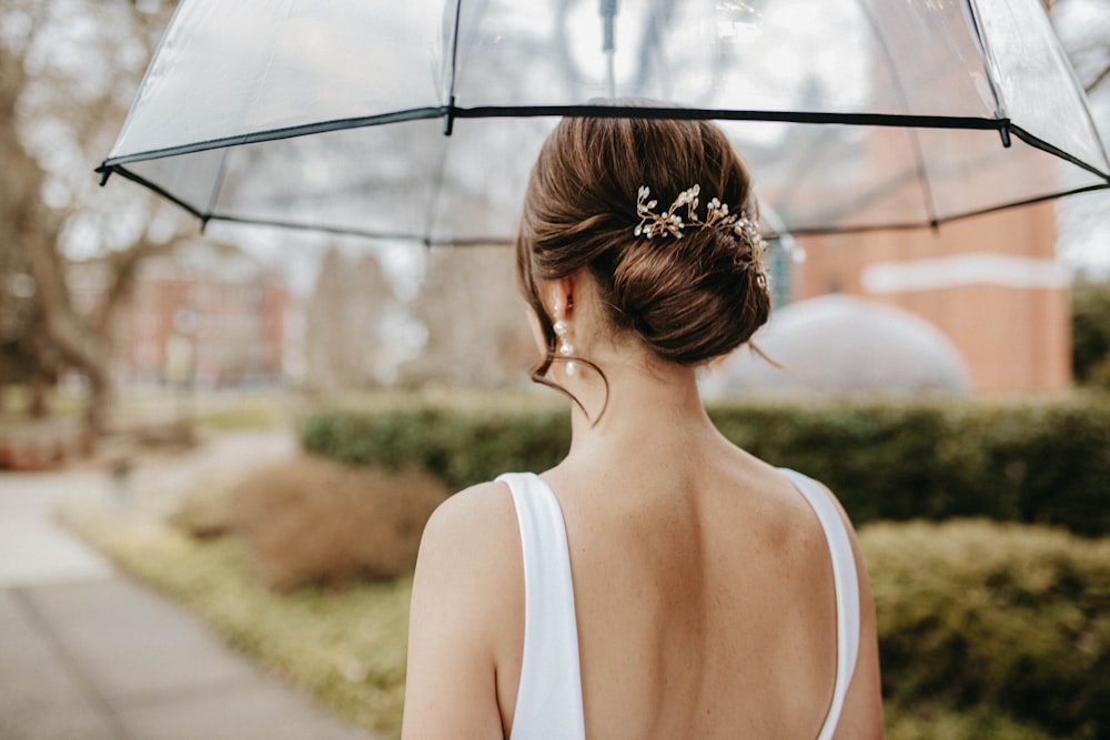 a woman in a white dress holding an umbrella