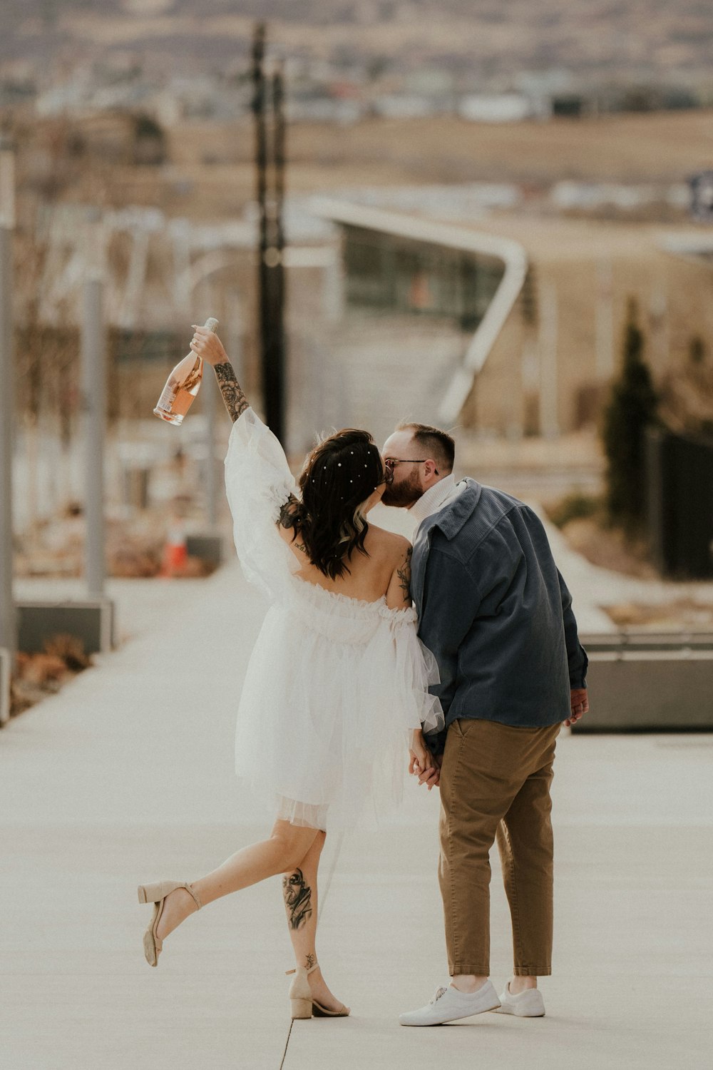 a bride and groom kissing on the street