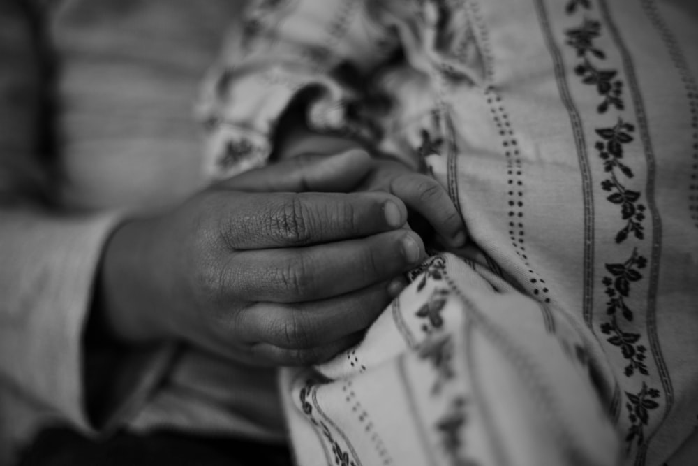 a close up of a person holding a baby's hand