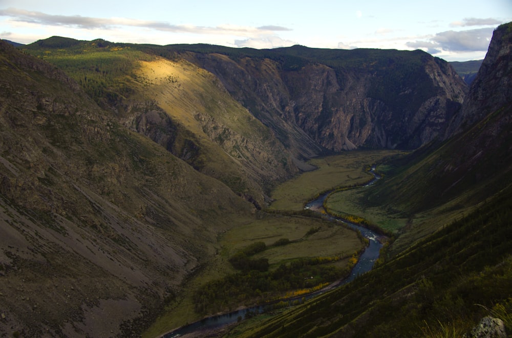 a river running through a valley surrounded by mountains