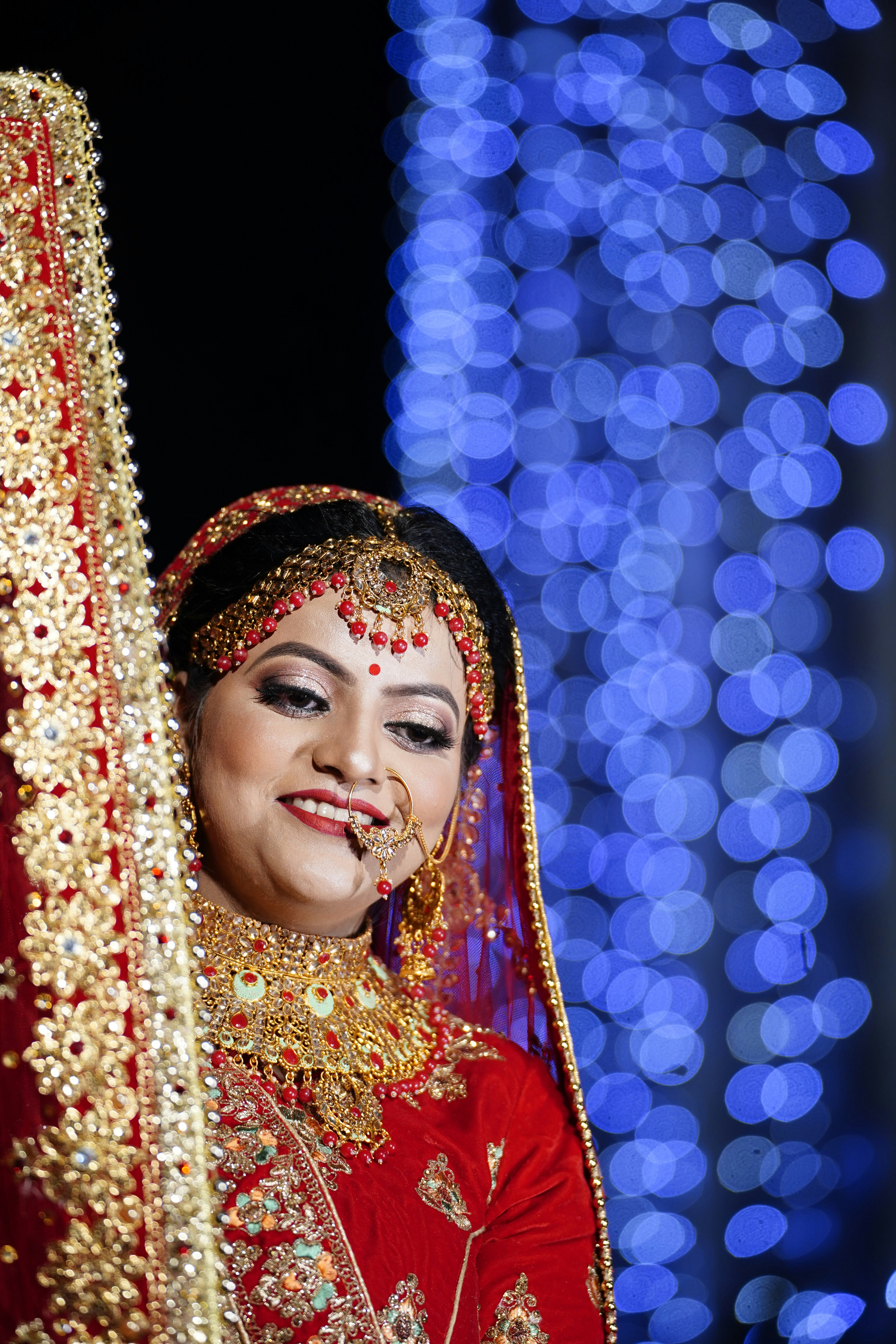 Bride looking at booking confirmation on phone, gold jewellery, warm indoor light