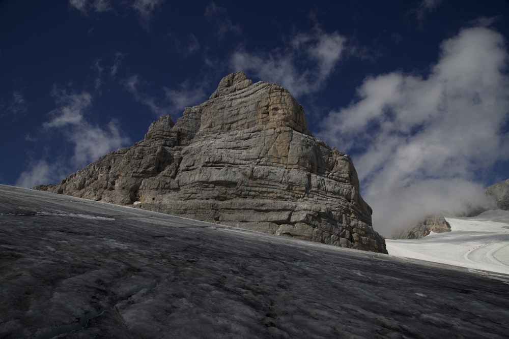 a snow covered mountain under a cloudy blue sky