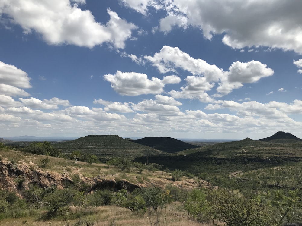 a scenic view of a mountain range under a cloudy sky