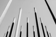 A towering abstract piece made from reclaimed steel beams against a minimalist backdrop.