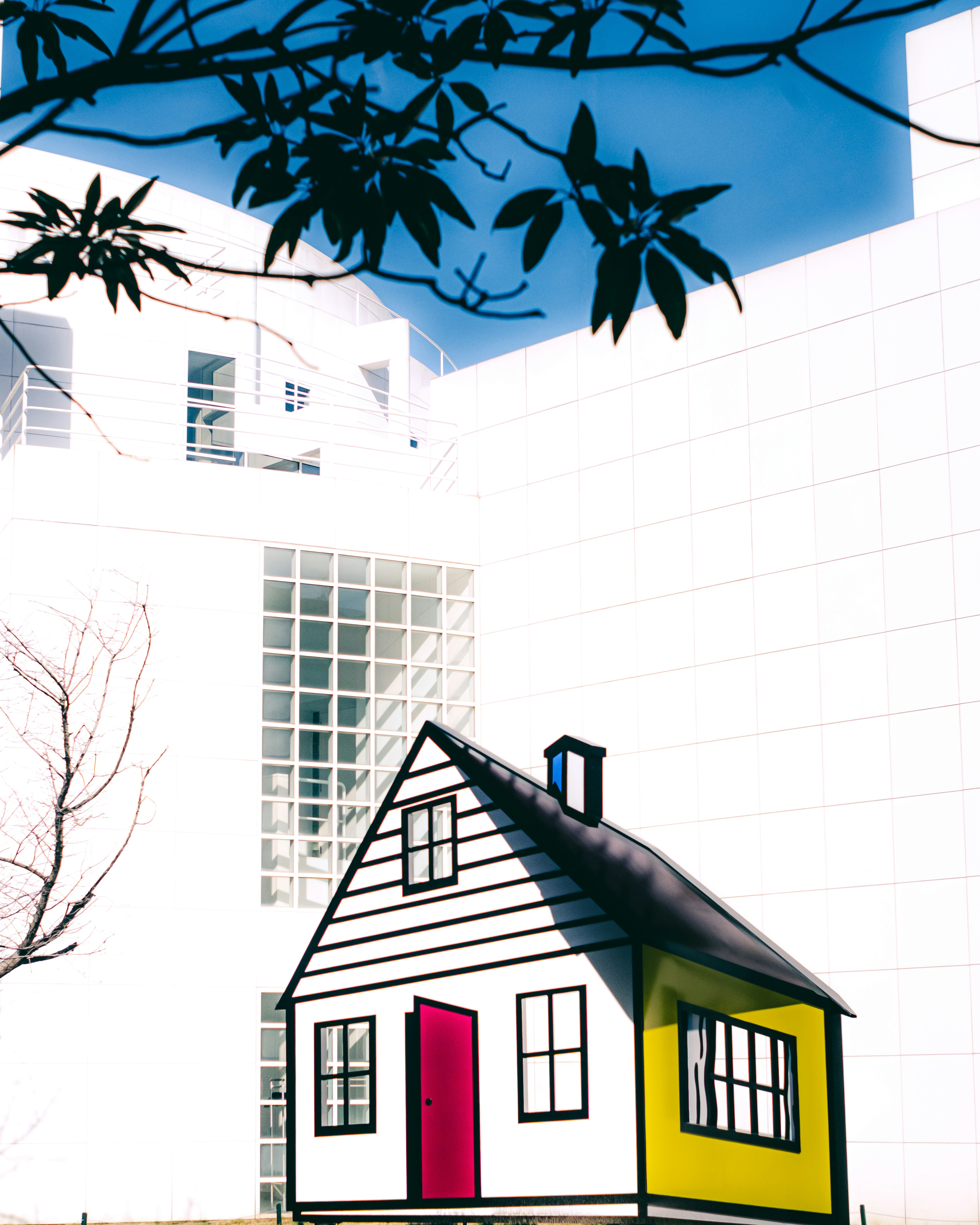 a white house with a red door and a yellow and red door