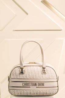 Dior handbag with signature stitching and metallic accents showcased against a sleek backdrop