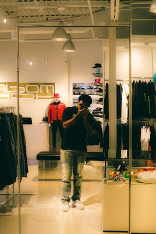 a man taking a picture of himself in a clothing store