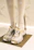 A stylish pair of black and gold sneakers displayed on a sleek marble surface.