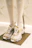 A stylish pair of black and gold sneakers displayed on a sleek marble surface.