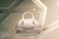A designer handbag is displayed against a stylish, geometric patterned background. The bag features a light color palette with elegant design elements and prominently showcases the brand 'Christian Dior' on the front.