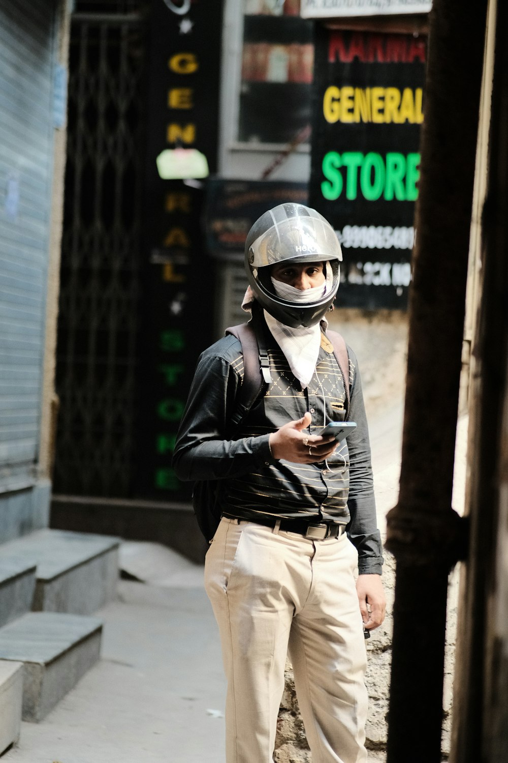 a man wearing a helmet and holding a cell phone