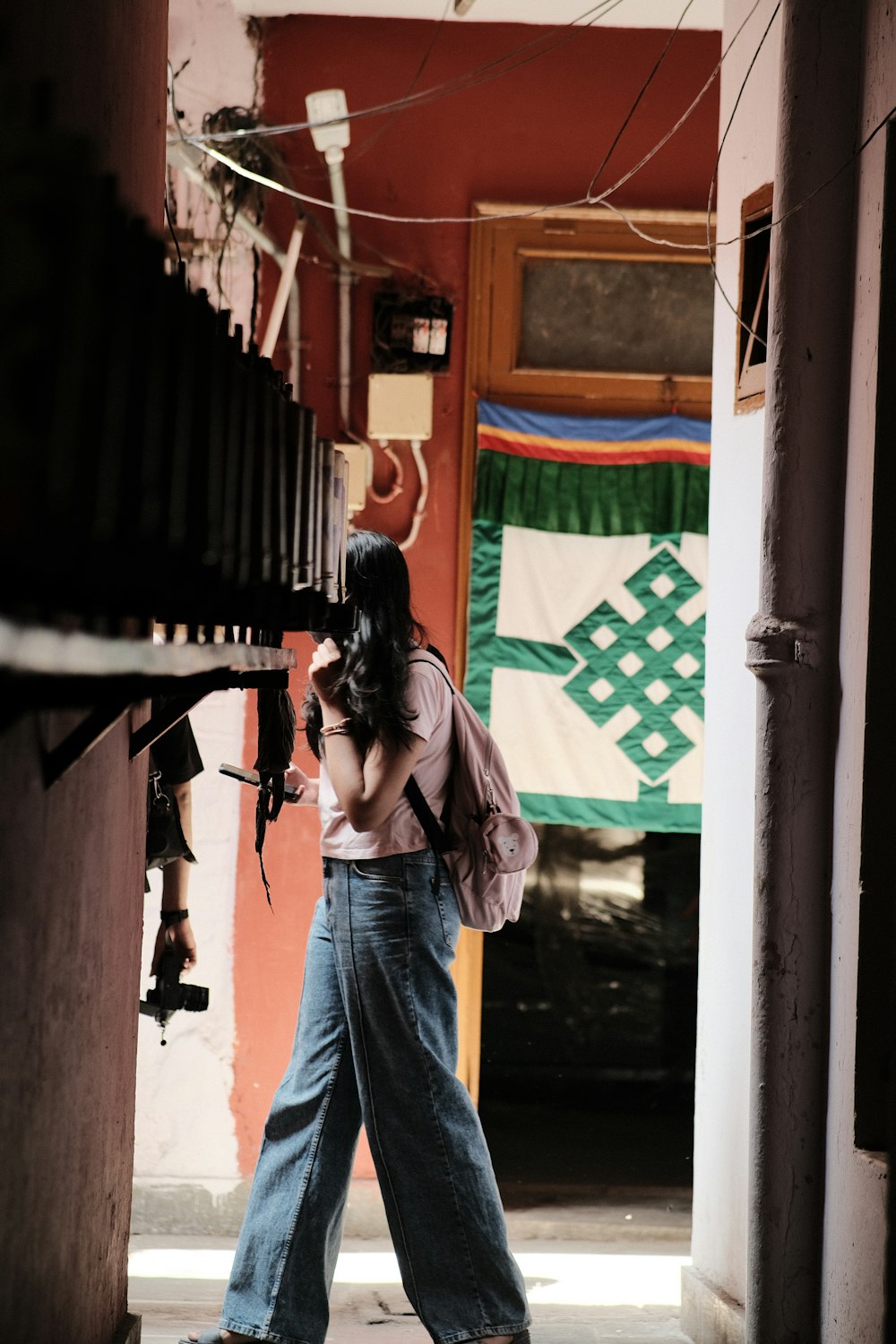 a woman walking down a hallway carrying a camera