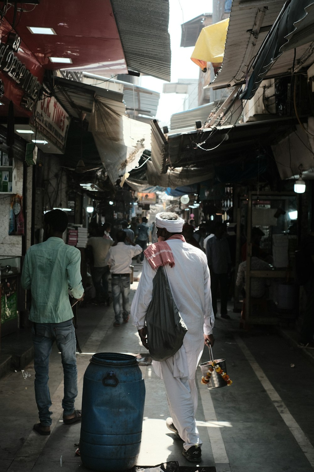 a man walking down a street next to a blue suitcase