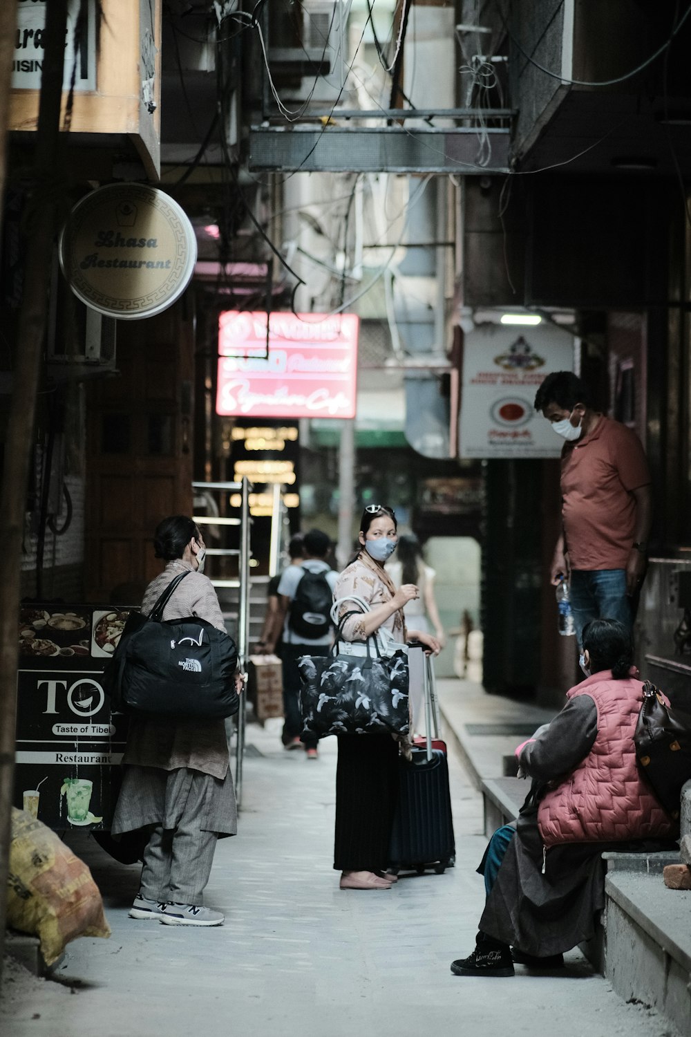 a group of people standing on a sidewalk with luggage