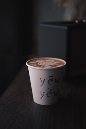 Close-up of a personalized cardboard cup with intricate client-requested artwork.
