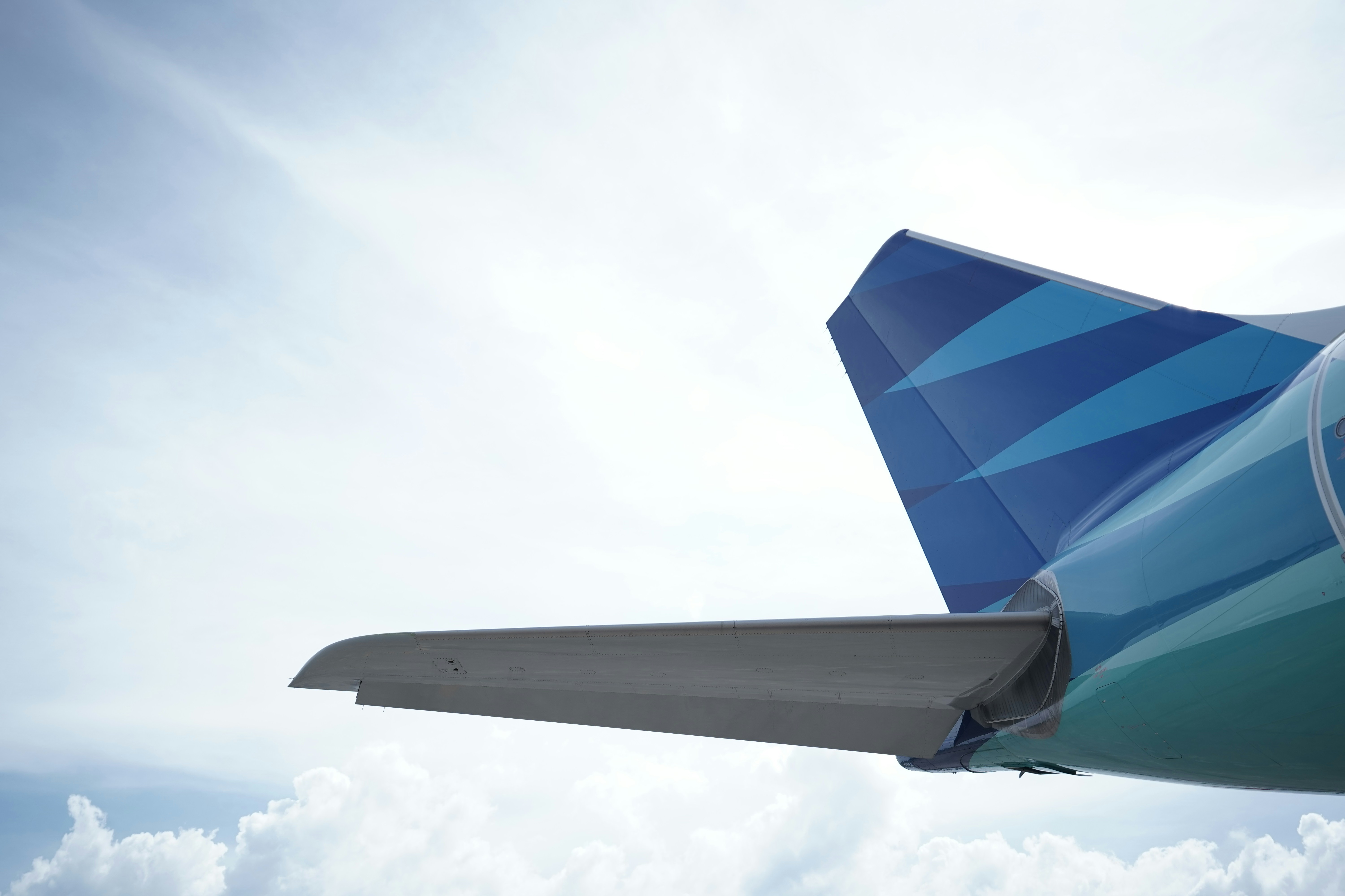 the tail end of an airplane flying in the sky