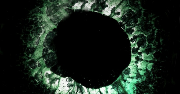 Close-up of a mysterious eye reflecting swirling cosmic patterns in dark tones.