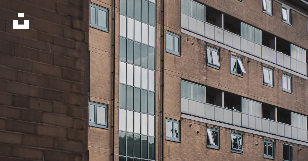 A tall brick building sitting next to a parking lot photo – Free Grey ...