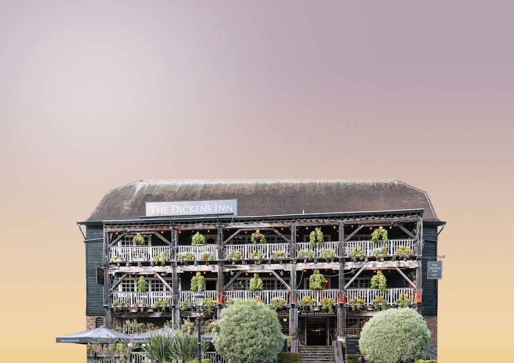 a building with a balcony and plants growing on it