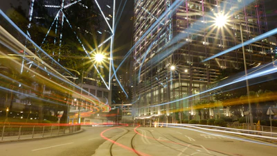 A high-resolution still from a cinematic urban night scene, showcasing vibrant lights and deep shadows.