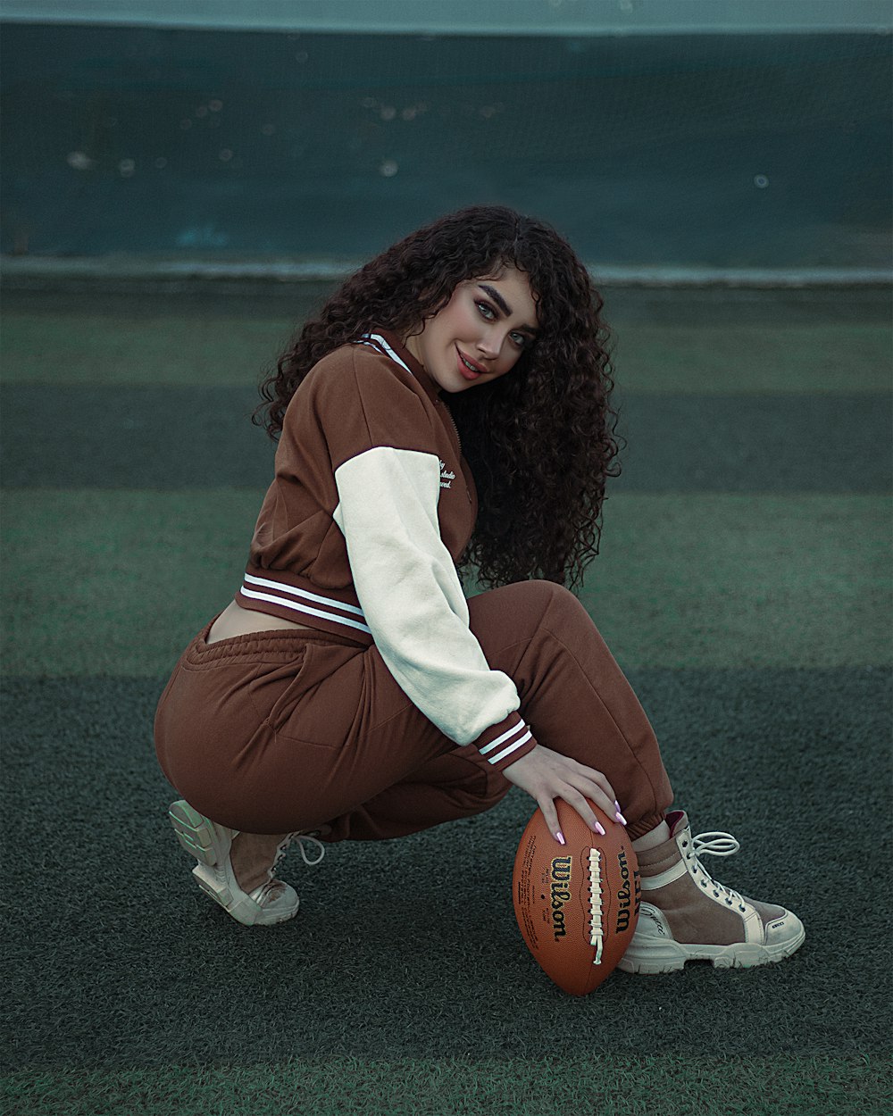 a woman kneeling down with a basketball in her hand