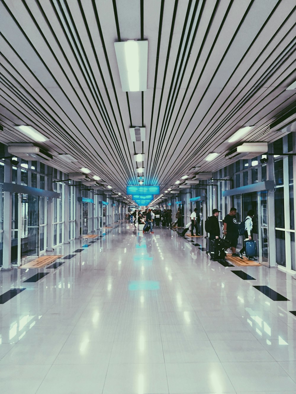 a group of people walking down a long hallway