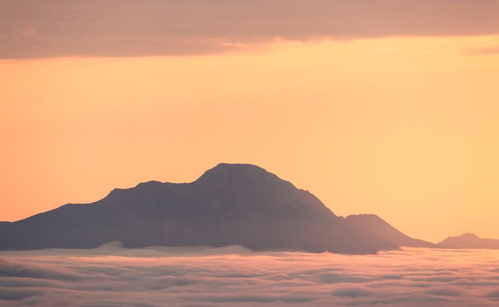 a mountain in the distance with clouds below