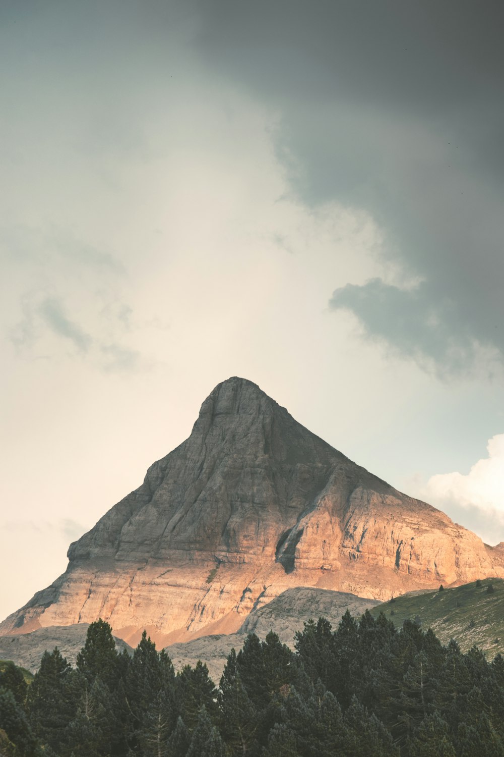 a large mountain with trees in front of it