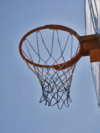 Close-up of a sleek basketball hoop against a clear blue sky.
