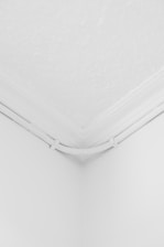 a corner of a room with a white ceiling