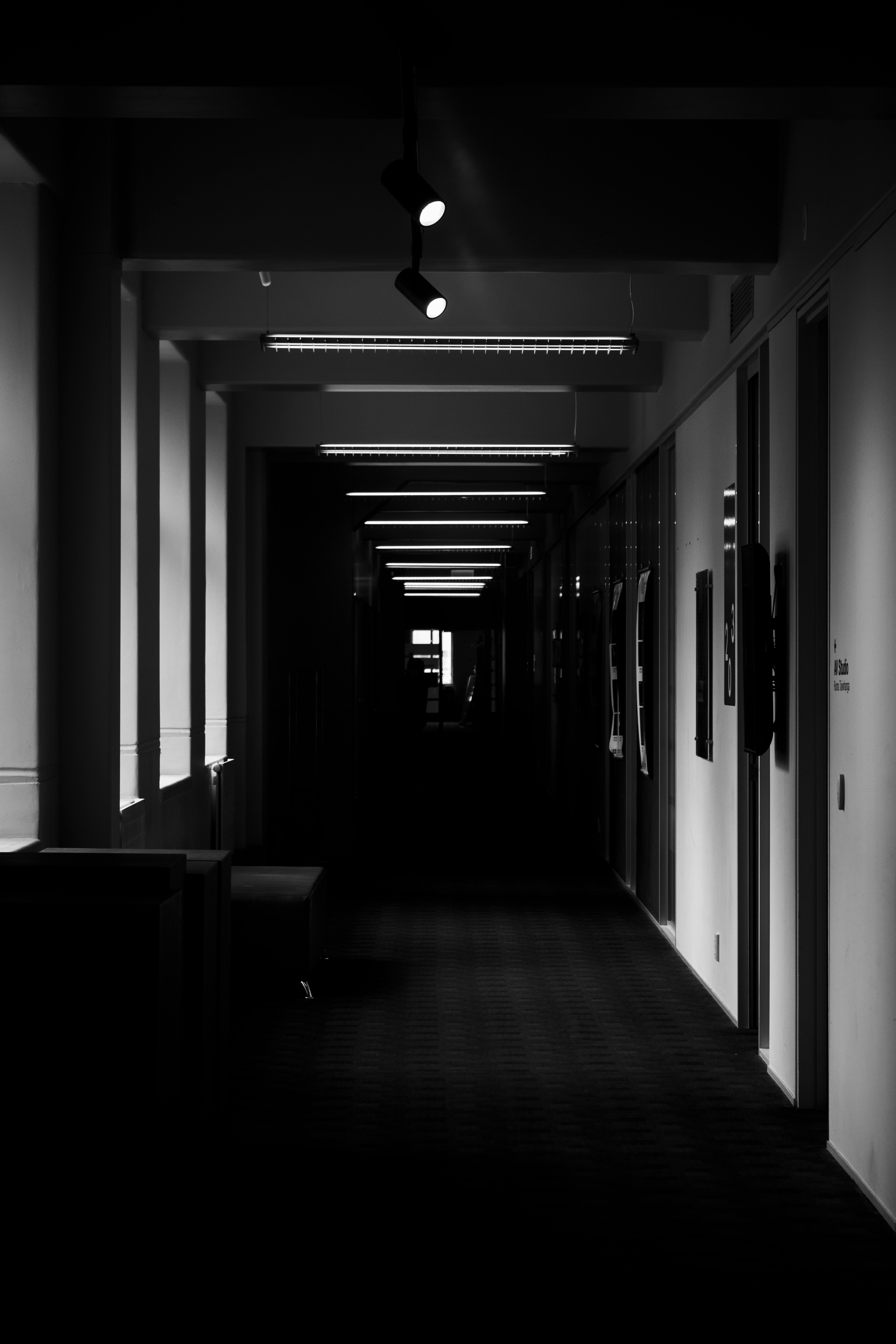 a dark hallway with a bench and lights