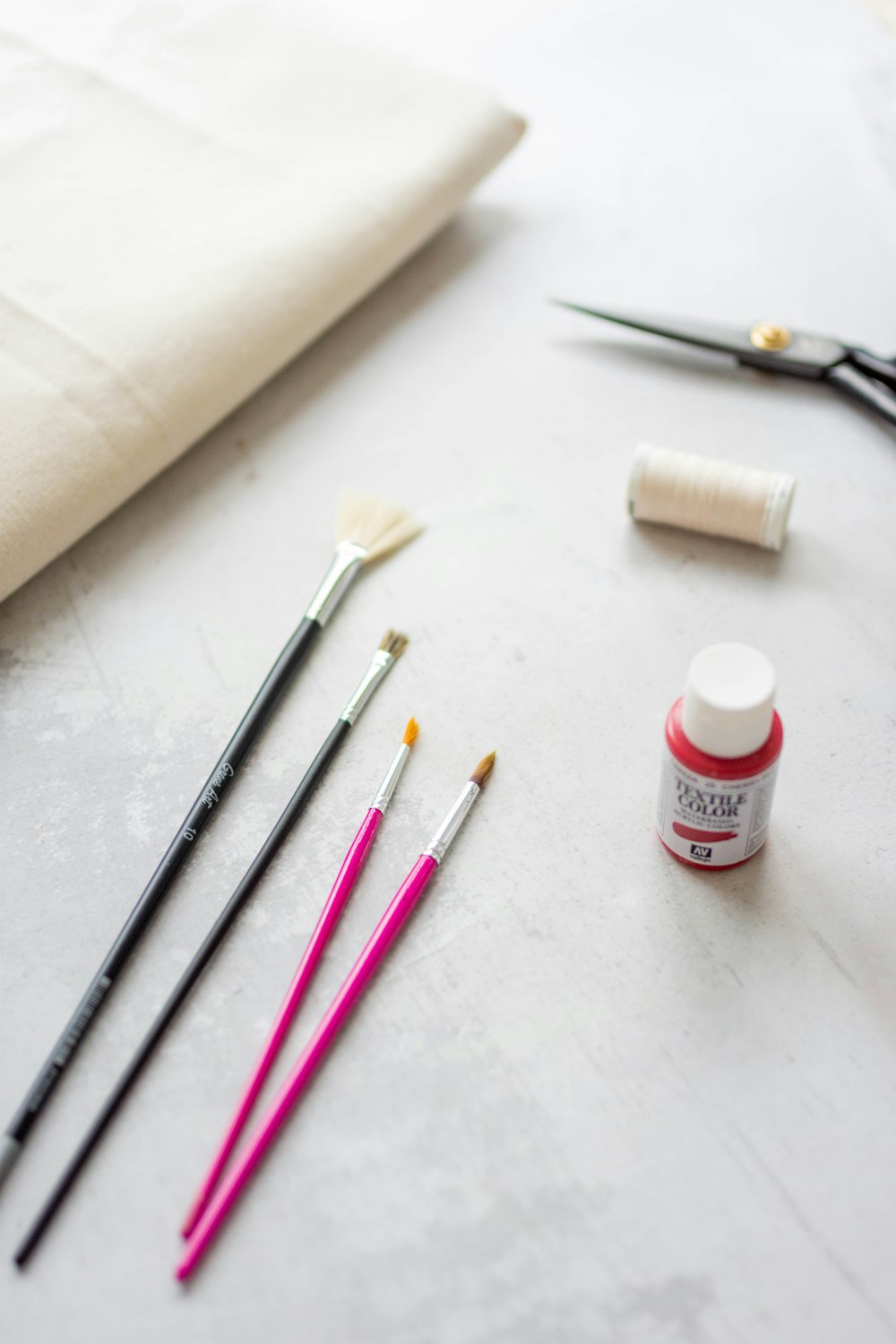 a table topped with different types of paint and brushes