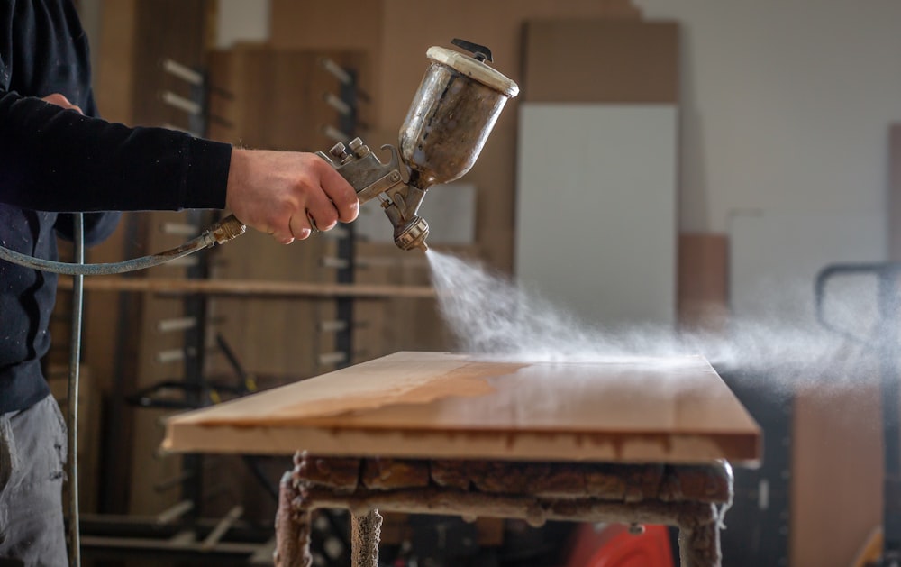 a person using a grinder on a wooden table