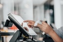 a person is using a pos machine in a store