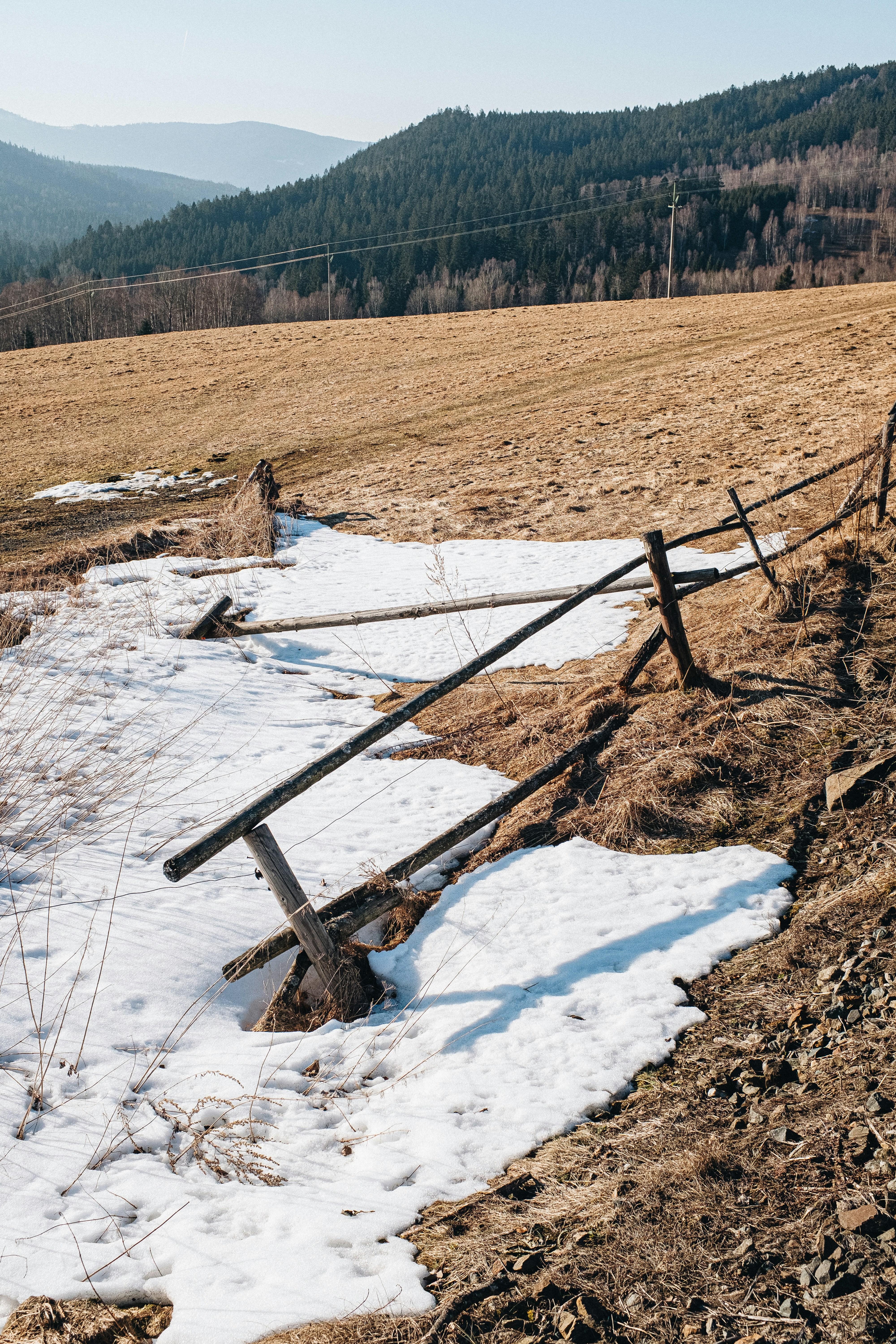a wooden fence in the middle of a snowy field