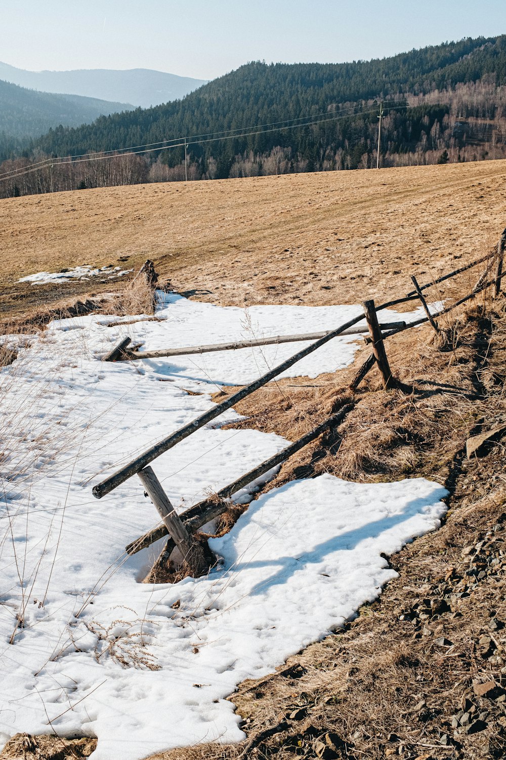 a wooden fence in the middle of a snowy field