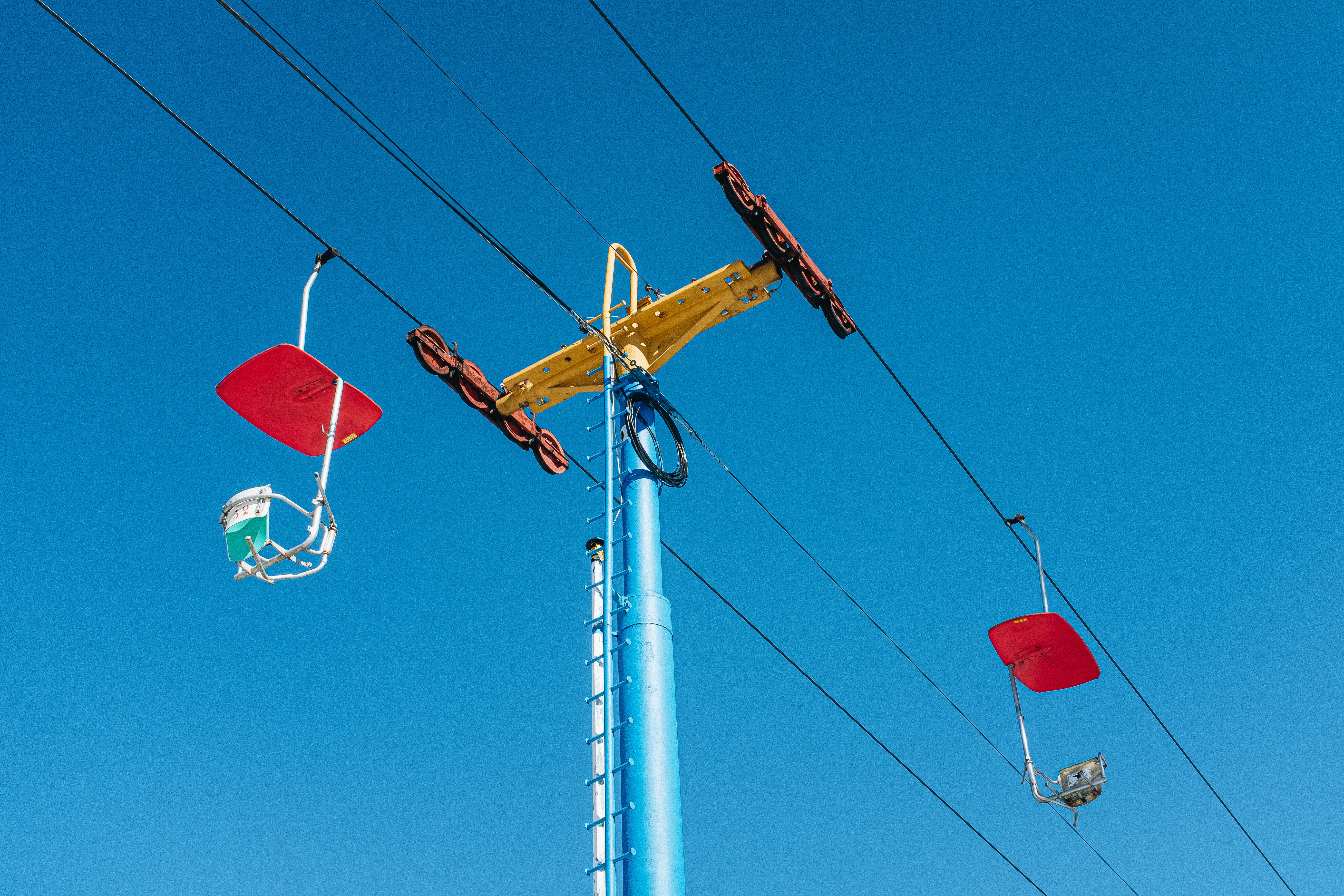 a yellow crane sitting on top of a blue pole
