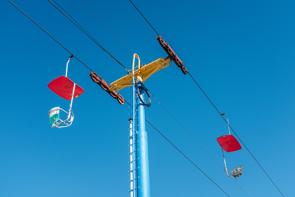 a yellow crane sitting on top of a blue pole