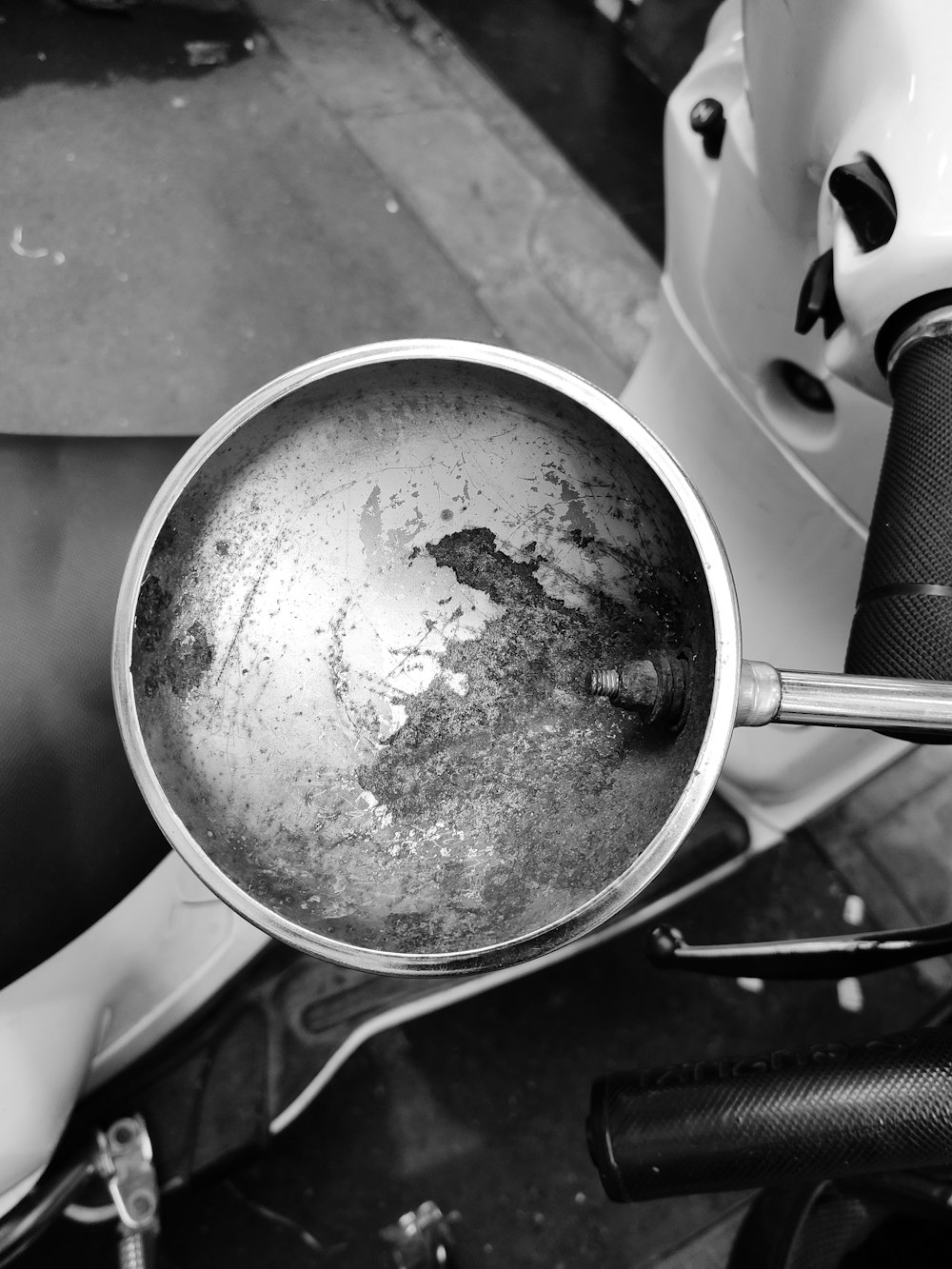 a dirty pan sitting on top of a motor scooter