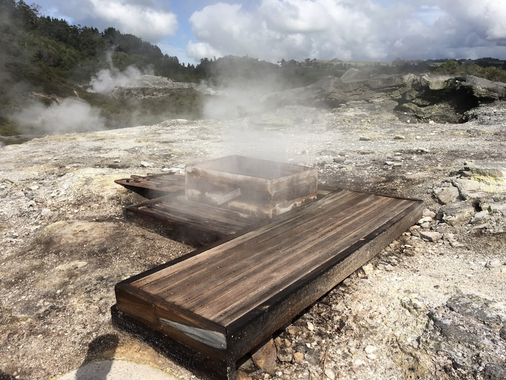 un banco de madera sentado en la cima de una ladera rocosa